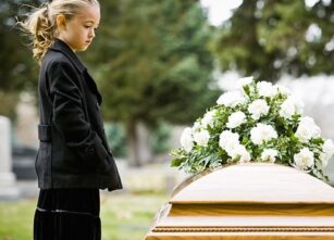 A kid beside a coffin