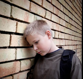 A boy leaning on a wall